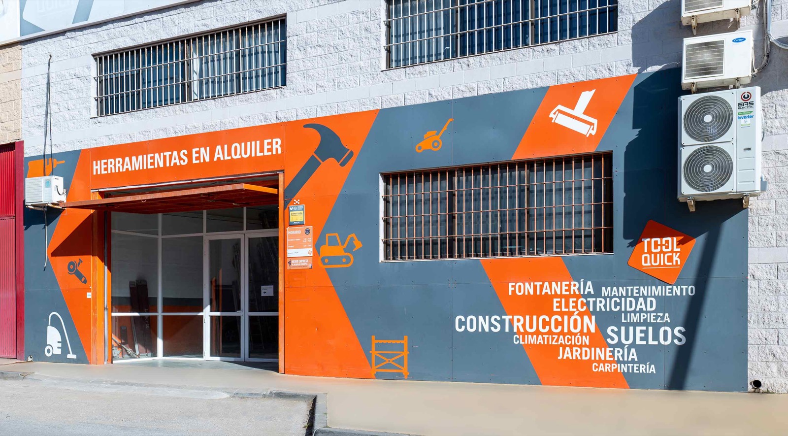 Lateral del edificio con pictogramas de herramientas y listado de sectores
